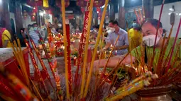 Warga mengunjungi sebuah kuil untuk menandai dimulainya Tahun Baru Imlek untuk menyambut Tahun Macan di Ta Khmao, provinsi Kandal, Kamboja pada 1 Februari 2022. (TANG CHHIN Sothy / AFP)