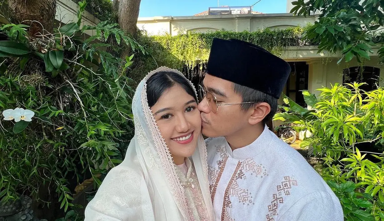 Potret bucin Kaesang dengan Erina. Masih di momen Idul Fitri, keduanya tampil menggunakan outfit berbeda. Kaesang berpose mencium pipi Erina dengan baju koko berwarna putih, sedangkan Erina yang tampak tersenyum mengenakan baju gamis berwarna broken white lengkap dengan selendang sebagai penutup kepala. Foto: Instagram.