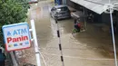 Aktivitas warga saat banjir merendam sejumlah pertokoan di sekitar Jalan Gunung Sahari, Jakarta, Selasa (25/2/2020). Hujan yang mengguyur Jakarta sejak Senin (24/2/2020) malam, membuat sejumlah kali meluap dan menyebabkan banjir. (Liputan6.com/Helmi Fithriansyah)