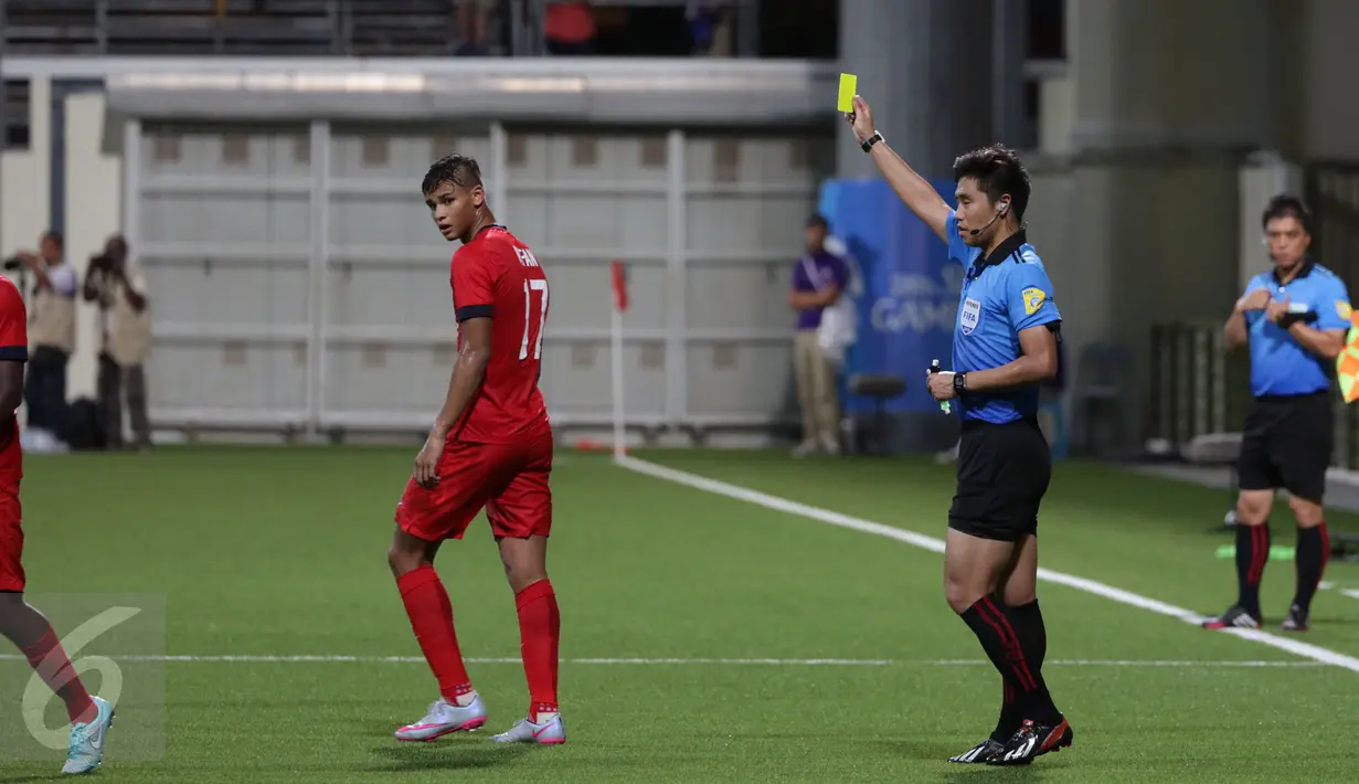Wasit Haegon Kim (kedua kanan) mengganjar pemain Singapura U-23, Irfan Fandi Ahmad saat laga melawan Indonesia di penyisihan Grup A SEA Games 2015 di Stadion Jalan Besar Singapura, Kamis (11/6/2015). Indonesia unggul 1-0. (Liputan6.com/Helmi Fithriansyah)