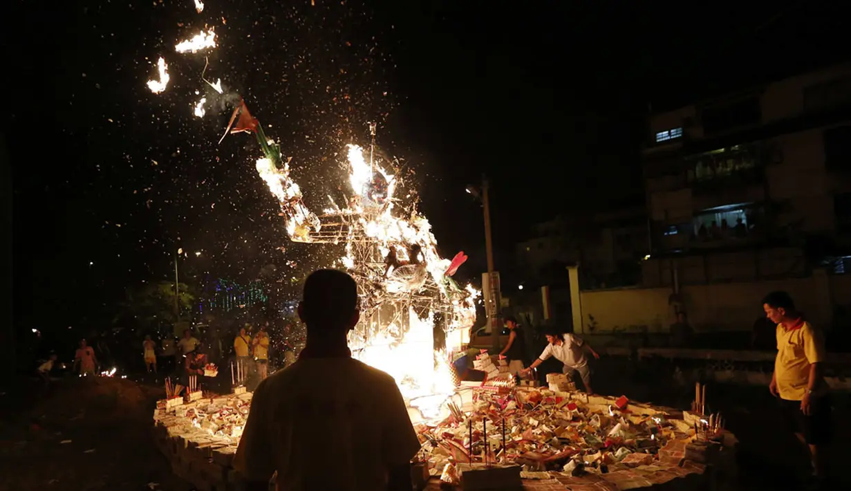 Makanan persembahan dan uang kertas serta dupa dibakar untuk menjaga roh-roh nenek moyang mati bahagia dan membawa keberuntungan, Kuala Lumpur, (3/8/2014). (REUTERS/Olivia Harris)