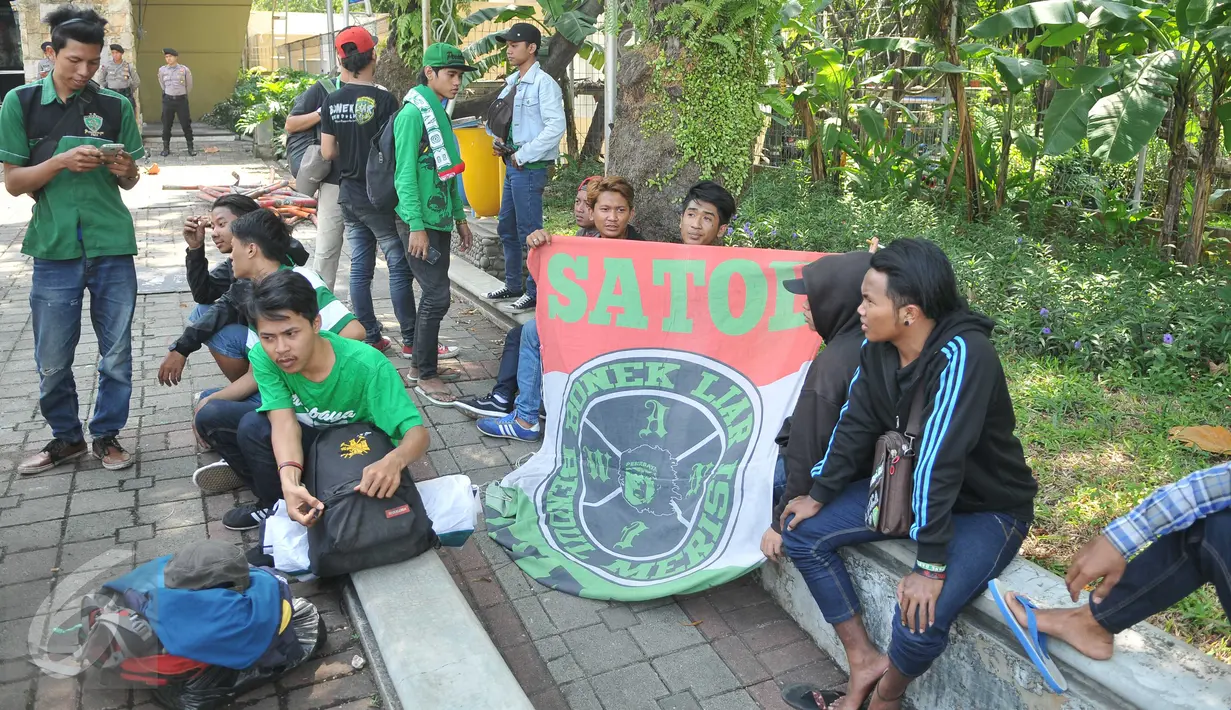 Sejumlah Bonek 1927, suporter klub sepak bola Persebaya Surabaya, duduk santai di luar lokasi berlangsungnya KLB PSSI di Ancol, Jakarta, Rabu (3/8). Para Bonek menuntut tim kesayangannya untuk bisa tampil dikompetisi resmi. (Liputan6.com/Gempur M Suray)