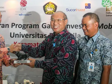 Direktur Pengembangan Bursa Efek Indonesia (BEI) Nicky Hogan (kiri) saat menerima cinderamata usai bersama Otoritas Jasa Keuangan (OJK) meluncurkan pilot project Galeri Investasi Mobile di Jagakarsa, Jakarta, Selasa (17/5). (Liputan6.com/Yoppy Renato)