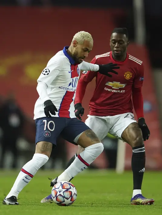 Penyerang Paris Saint Germain (PSG), Neymar berusaha menahan bek Manchester United atau MU, Aaron Wan-Bissaka pada matchday kelima Grup H Liga Champions di Stadion Old Trafford, Kamis (3/12/2020) dinihari WIB. MU keok 1-3 dari PSG. (AP Photo/Dave Thompson)