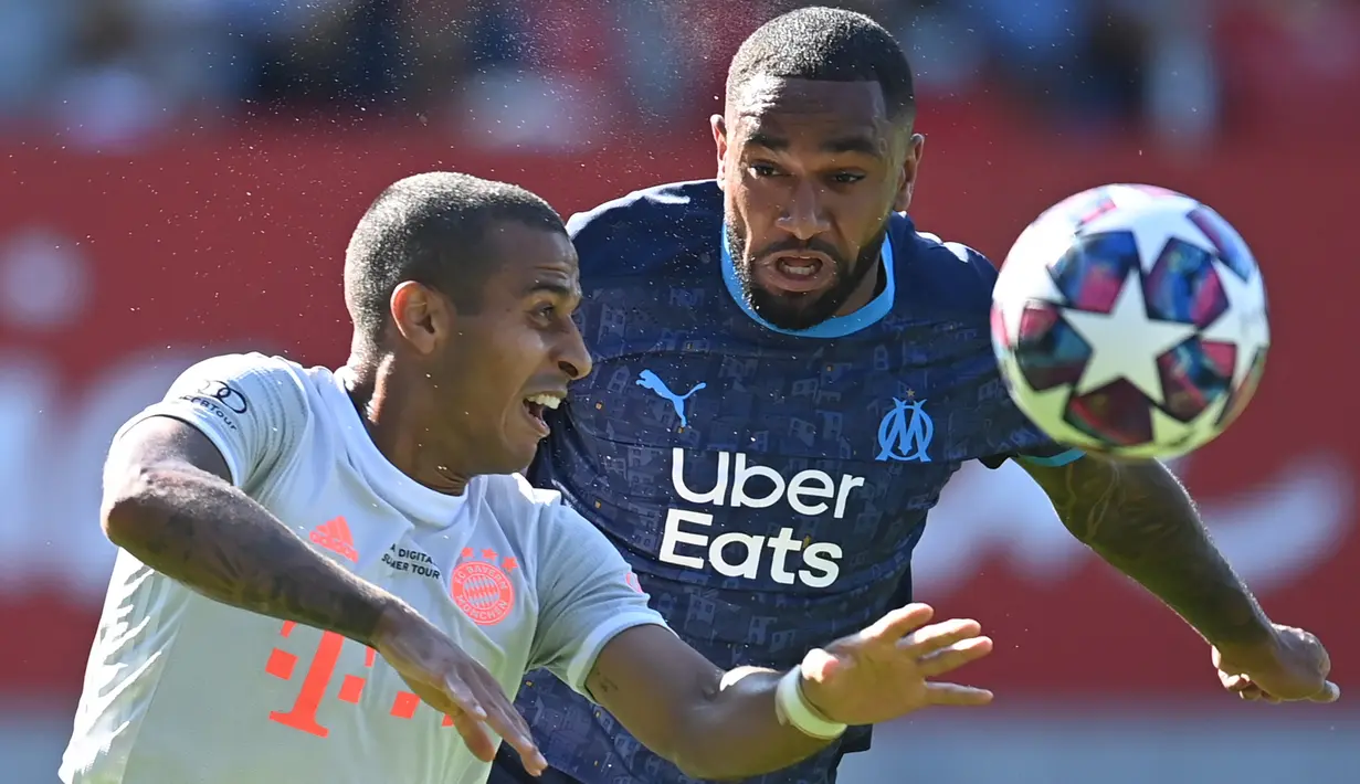 Gelandang Bayern Munchen, Thiago Alcantara, berebut bola dengan bek Marseille, Jordan Amavi, pada laga persahabatan di Allianz Arena, Sabtu (1/8/2020) dini hari WIB. Bayern Munchen menang 1-0 atas Marseille. (AFP/Christof Stache/various sources)