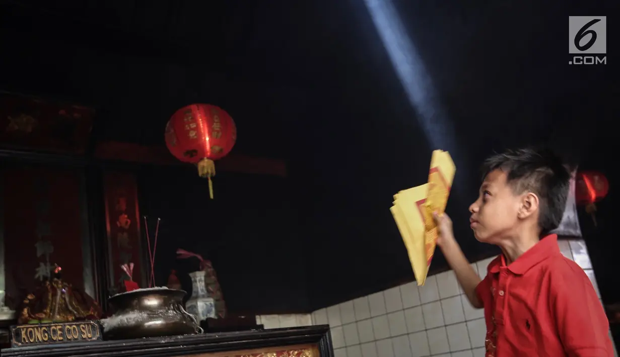 Anak membawa kertas Kim Lou pada perayaan Tahun Baru Imlek 2570 di Vihara Boen Tek Bio, Pasar Lama, Tangerang, Selasa (5/2). Tahun Baru Imlek 2570 digunakan warga keturunan Tionghoa untuk memanjatkan doa yang baik. (Liputan6.com/Fery Pradolo)