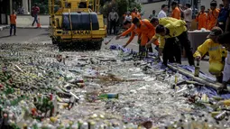 Petugas dibantu dengan alat berat buldoser memusnahkan minuman keras di Polres Jakarta Utara, Selasa (16/5). Pemusnahan diharapkan muncul situasi keamanan dan ketertiban masyarakat (kamtibmas) yang kondusif. (Liputan6.com/Faizal Fanani)