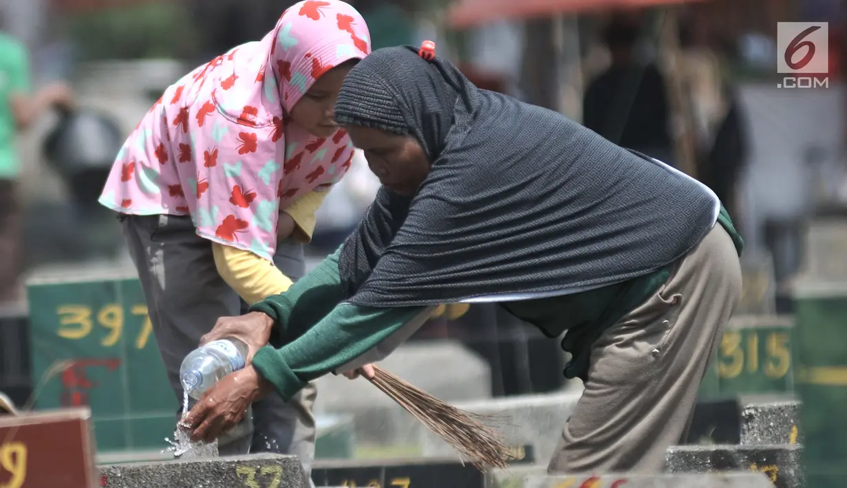 Seorang anak bersama ibunya membersihkan salah satu makam di TPU Penggilingan, Pulogadung, Jakarta, Kamis (10/5). Tradisi ziarah jelang Ramadan menjadi berkah bagi anak-anak pembersih makam atau biasa dikenal 'Ngoret'. (Merdeka.com/Iqbal S. Nugroho)