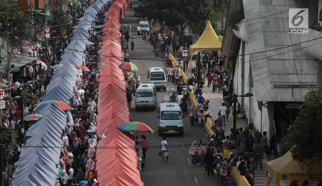 Sejumlah angkutan kota Tanah Abang melintasi Jalan Jatibaru Raya, Jakarta, Sabtu (3/2). Angkot hanya diperbolehkan melintas di satu ruas jalan saja, depan Stasiun Tanah Abang dan satu ruas lagi tetap digunakan PKL berjualan. (Liputan6.com/Arya Manggala)