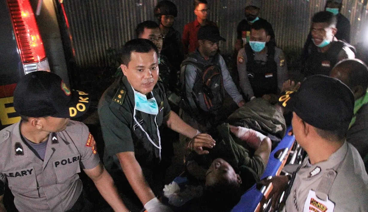 Polisi dan tim medis membawa seorang anggota Brimob yang tertembak saat kontak tembak dengan Kelompok Kriminal Bersenjata (KKB) di Nduga, Papua, Rabu (5/12). Korban saat ini mendapat perawatan medis di sebuah rumah sakit di Wamena. (ANYONG/AFP)