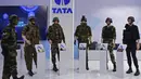 Seorang tentara India (kiri) melihat berbagai pakaian tempur yang dipajang di Tata Aerospace and Defense dome selama Defense Expo 2022 di Gandhinagar, India, 18 Oktober 2022. Defense Expo 2022 ini akan berlangsung selama lima hari. (Sam PANTHAKY/AFP)