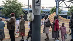 Para pasien mengantre untuk masuk ke kereta Phelophepa, yang diparkir di stasiun kereta Dube di Soweto, pada 10 Oktober 2023. (MARCO LONGARI/AFP)