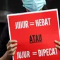 Peserta aksi dari Koalisi Masyarakat Sipil AntiKorupsi membawa poster saat berunjukrasa di depan Gedung KPK Jakarta, Selasa (18/5/2021). Dalam aksinya mereka memberi dukungan kepada 75 pegawai KPK yang dinyatakan tidak lulus TWK dalam tahap alih status kepegawaian. (Liputan6.com/Helmi Fithriansyah)