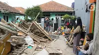 Warga berkumpul dekat bangunan yang roboh akibat gempa di Kampung Kadudampit, Kabupaten Cianjur, Jawa Barat, Selasa (22/11/2022. Data dari BPBD Kabupaten Cianjur mencatat, hingga pukul 21.30 WIB sebanyak 162 orang meninggal dunia, 326 warga luka-luka, dan 13.784 warga mengungsi. (Liputan6.com/Herman Zakharia)