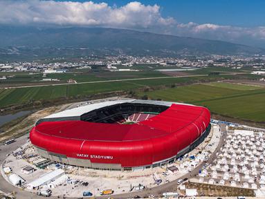 Foto udara menunjukkan sebuah kamp darurat pengungsi gempa Turki di sebelah Stadion New Hatay di Antakya, Turki Selatan, pada tanggal 22 Februari 2023. Gempa berkekuatan 6,4 magnitudo kembali mengguncang provinsi selatan Turki, Hatay, dan Suriah Utara, menewaskan enam orang dan memicu kepanikan baru setelah gempa besar pada 6 Februari lalu yang menewaskan hampir 45.000 orang di kedua negara tersebut. (Sameer Al-DOUMY/AFP)