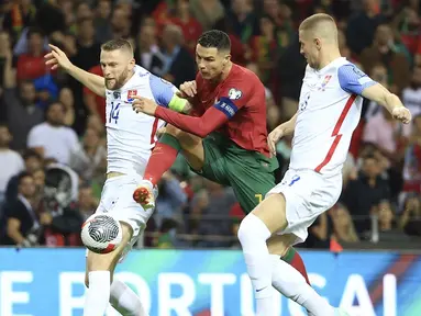 Pemain Portugal, Cristiano Ronaldo, berusaha melewati pemain Slovakia, Milan Skriniar dan Denis Vavro, pada laga Kualifikasi EURO 2024 di Stadion Dragao, Sabtu (14/10/2023). Portugal menang dengan skor 3-2. (AP Photo/Luis Vieira)
