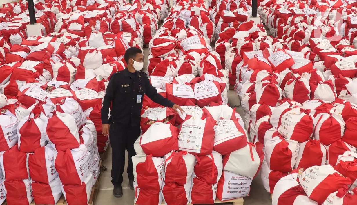 Petugas memeriksa bantuan paket sembako dari Presiden Joko Widodo di Tangerang, Sabtu (9/6/2020). Ribuan paket sembako tersebut akan didistribusikan kepada warga kurang mampu di wilayah Bodetabek guna mengurangi beban ekonomi mereka di tengah pandemi COVID-19. (Liputan6.com/Angga Yuniar)