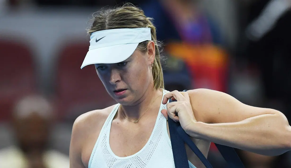 Maria Sharapova tertunduk setelah pertandingan melawan Simona Halep dari Rumania pada  turnamen tenis China Terbuka di Diamond Court di Beijing, Rabu, (4/10). Sharapova kalah 6-2 6-2 dalam waktu 72 menit dari Halep. (AFP Photo/Greg Baker) 