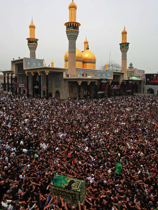 Ribuan umat Syiah Irak mengiringi peti jenazah yang menyimbolkan Musa al-Kadhim di Kadhimiya, Irak (12/4). Imam Musa al-Kadhim adalah imam ketujuh dari 12 imam Syiah yang meninggal pada 799. (AFP Photo/Ahmad Al-Rubaye)