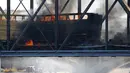 Kereta barang tergelincir dan terbakar di jembatan Danau Kota Tempe, Arizona, Amerika Serikat, Rabu (29/7/2020). Beberapa mobil yang dimuat kereta tersebut dilaporkan turut terbakar. (AP Photo/Ross D. Franklin)