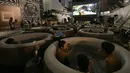 Pengunjung menikmati menonton film sambil berendam di Bathtub Cinema di atap gedung kawasan Shibuya, Tokyo, 17 Agustus 2018. Bagi para peminatnya harus merogoh kocek sebesar 18 ribu yen atau setara dengan Rp 2,3 juta per bathtub. (AFP/Kazuhiro NOGI)