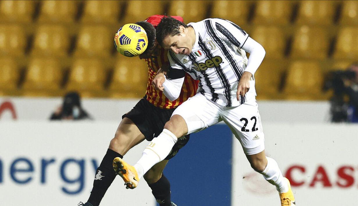 Pemain Juventus, Federico Chiesa, duel udara dengan pemain Benevento pada laga Liga Italia di Stadion Vigorito, Sabtu (28/11/2020). Kedua tim bermain imbang 1-1. (Alessandro Garofalo/LaPresse via AP)