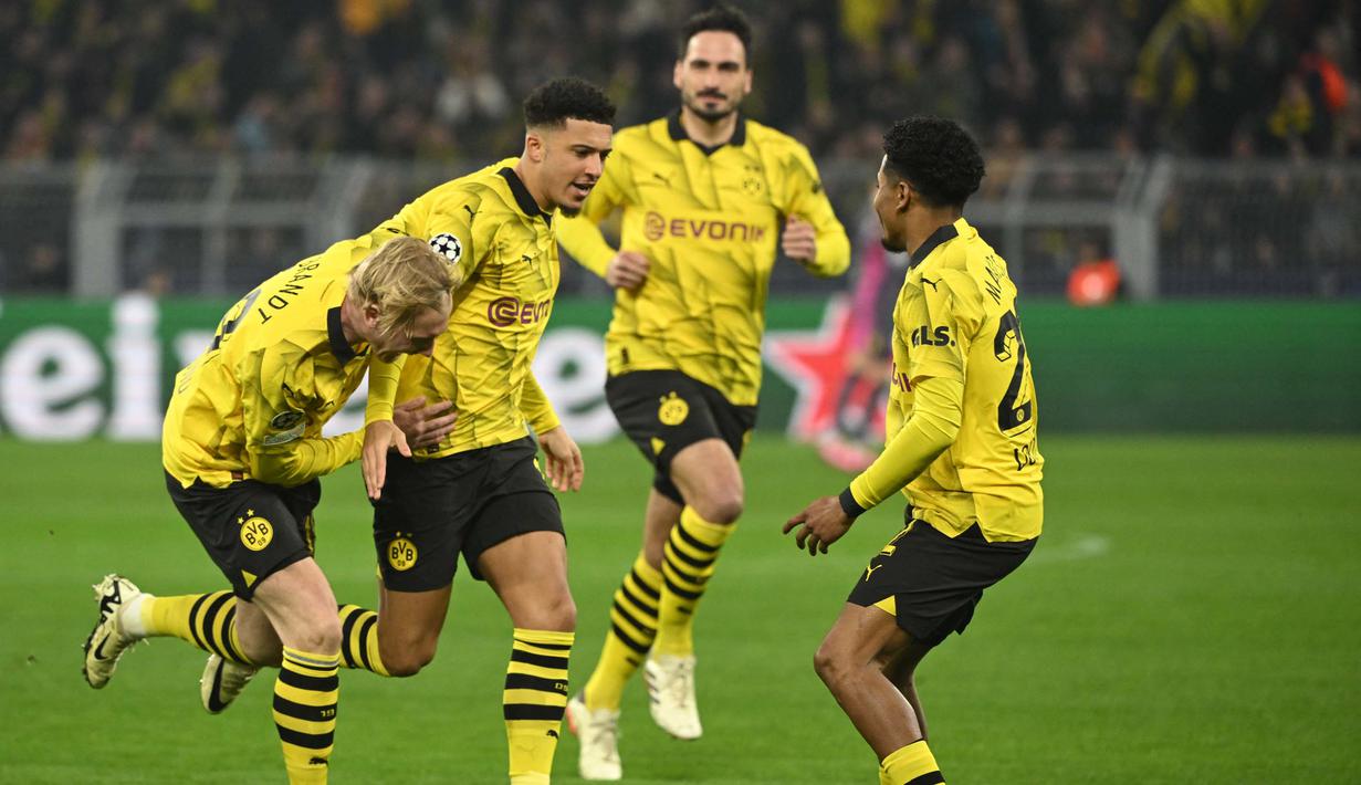 Gelandang Borussia Dortmund, Jadon Sancho (kedua kiri) berselebrasi usai mencetak gol pembuka saat pertandingan sepak bola leg kedua babak 16 besar Liga Champions melawan PSV Eindhoven di Stadion Signal Iduna, Dortmund, Jerman, 13 Maret 2024. (INA FASSBENDER/AFP)