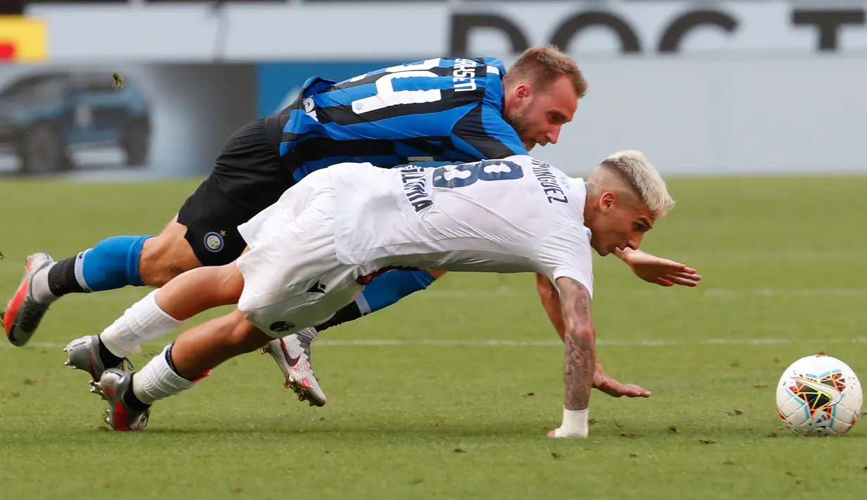 Gelandang Inter Milan, Christian Eriksen dan pemain Bologna, Nicolas Dominguez  terjatuh saat berebut bola pada pekan ke-30 Serie A 2019-2020, di Stadion Giuseppe Meazza, Minggu (5/7/2020). Inter Milan ditumbangkan Bologna 1-2 di kandang sendiri. (AP /Antonio Calanni)