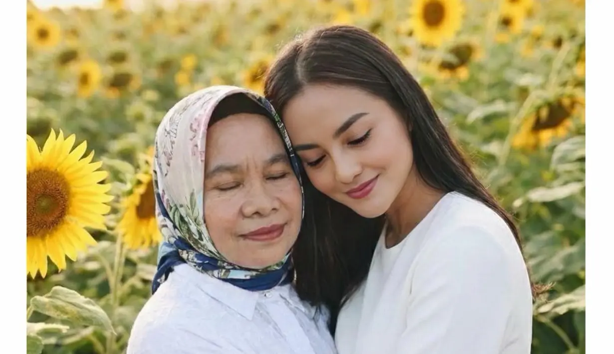 Ririn Ekawati andalkan AI untuk obati rasa rindunya pada sang ibu. Berlatar taman bunga matahari, Ririn Ekawati nampak memeluk sang ibu dalam balutan atasan putih yang serasi [@ririnekawati]