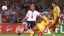 Striker Timnas Inggris, Alan Shearer (kiri) berebut bola dengan bek Rumania, Dan Petrescu pada laga Grup G Piala Dunia 1998 di Touluose Stadium, Prancis (22/6/1998). Hingga pensiun pada Juli 2006, Alan Shearer total tampil dalam 63 laga bersama Timnas Inggris dengan torehan 30 gol dan 11 assist. Pada laga debutnya menghadapi Prancis (19/2/1992) jelang Piala Eropa 1992, ia langsung mencetak satu gol dan membawa Inggris menang 2-0. (AFP/Jacques Demarthon)
