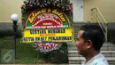 Pekerja melintas di depan karangan bunga ucapan selamat dilantiknya Komjen Pol Tito Karnavian di Mabes Polri, Jakarta, Rabu (13/7). Tito Karnavian akan dilantik menjadi Kapolri di Istana Negara oleh Presiden Jokowi. (Liputan6.com/Helmi Fithriansyah)