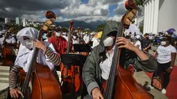 Musisi dari National System of Orchestras of Venezuela berusaha memecahkan rekor dunia bermain orkestra terbesar di dunia, di Caracas pada 13 November 2021. Rekor konser terbesar saat ini masih dipegang oleh Rusia sejak 2019 dengan peserta 8.097 musisi. (Federico PARRA/AFP)