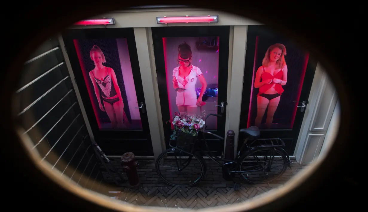 Gambar tiga perempuan pekerja seks terlihat di tiga pintu di Red Light Secrets Museum of Prostitution, Amsterdam Belanda (1/4). Pemerintah Amsterdam mengumumkan bakal segera mengakhiri tur wisata ke Red Light District. (AP Photo/Peter Dejong)