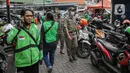 Petugas Satpol PP mendatangi gerai cepat saji McDonald's Raden Saleh, Jakarta, Rabu (9/6/2021). Puluhan driver ojek online terlihat mengabaikan protokol kesehatan saat mengantre pesanan BTS Meal yang mulai dijual. (Liputan6.com/Faizal Fanani)