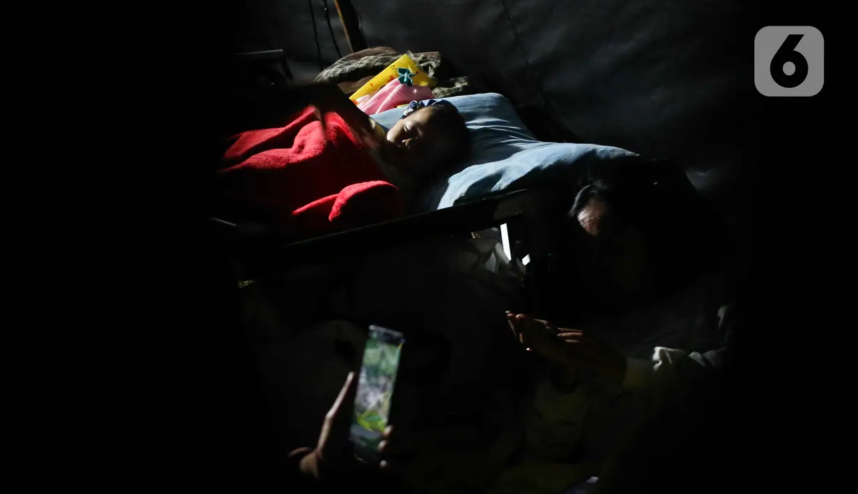 Seorang anak tidur di posko pengungsian di Taman Prawatasari, Kabupaten Cianjur, Jawa Barat, Selasa (22/11/2022). Gubernur Jawa Barat Ridwan Kamil menyebut, sebanyak 14 posko pengungsian didirikan untuk memfasilitasi warga berjumlah 13.784 pengungsi yang terdampak gempa berkekuatan 5,6 SR di Kabupaten Cianjur. (Liputan6.com/Herman Zakharia)