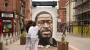 Warga mengamati mural George Floyd di Manchester tengah, Inggris (4/6/2020). George Floyd tewas kehabisan napas saat dalam penahanan pihak kepolisian Negara Bagian Minnesota, wilayah Midwest Amerika Serikat, pada pekan lalu. (Xinhua/Jon Super)