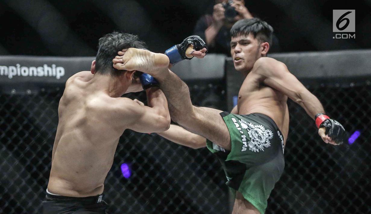 Dua petarung Indonesia, Rizki Umar (kanan) melakukan tendangan ke petarung Arnol Batubara (kiri) saat berlaga pada partai pertama dalam One Championship di Jakarta, Sabtu (20/1). Rizki Umar menang pada partai pertama. (Liputan6.com/Faizal Fanani)