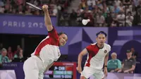 Pemain ganda campuran Indonesia, Pitha Haningtyas Mentari berusaha mengembalikan bola smes yang dilepaskan lawannya, wakil China Zheng Siwei/Huang Yaqiong pada laga Grup A nomor ganda campuran bulu tangkis Olimpiade Paris 2024 di Porte de la Chapelle Arena, Prancis, Minggu (28/7/2024). Rinov/Pitha kalah 0-2 (10-21, 3-21). (AP Photo/Dita Alangkara)