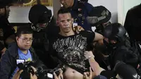 Polisi menahan penyandera Alchie Paray saat ia berbicara kepada media tak lama setelah melepaskan semua sandera di V-Mall di Manila, Filipina pada hari Senin, 2 Maret 2020. (AP Photo/Aaron Favila)