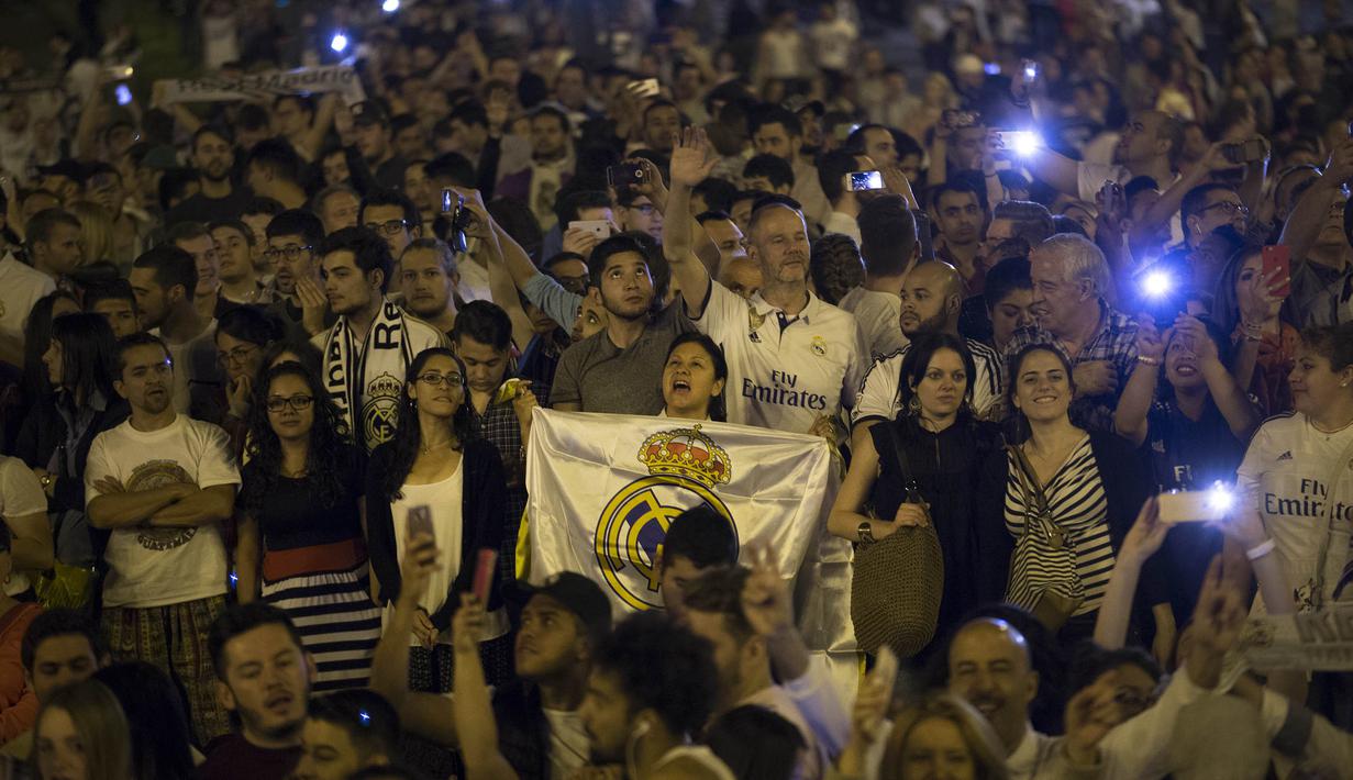 Suporter merayakan keberhasilan Real Madrid menjuarai La Liga Spanyol di Lapangan Cibeles, Madrid, (22/05/2017). Real Madrid meraih juara La Liga untuk ke-33 kalinya. (AP/Francisco Seco)