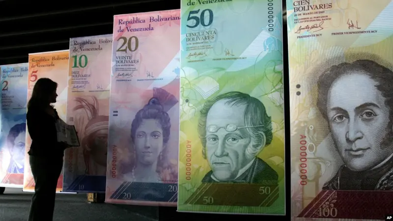 Seorang perempuan melihat versi besar mata uang Venezuela baru, yang disebut 'Strong Bolivar' di Caracas pada 2013, sebagai ilustrasi. (Foto: AP)