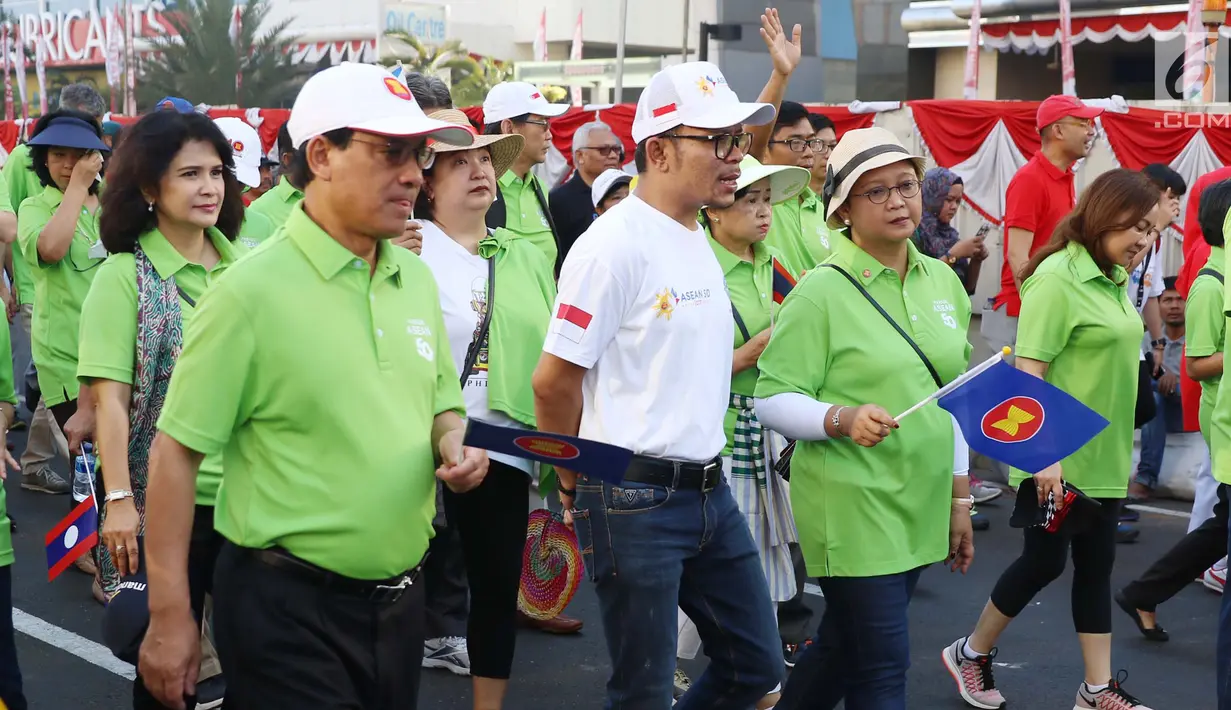 Menlu Retno Marsudi bersama Kemenaker Trans Hanif Dhakiri saat mengikuti Parade Asean 50 Tahun di Jakarta, Minggu (27/8). Acara ini menampilkan Parade Bendera ASEAN, Parade kostum, Parade tari musik, dan keunikan lainnya. (Liputan6.com/Angga Yuniar)