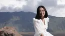 Gisella Anastasia tersenyum saat menari dengan latar belakang keindahan Gunung Bromo untuk syuting video musik dari Setian Band. (Instagram/gisel_la)