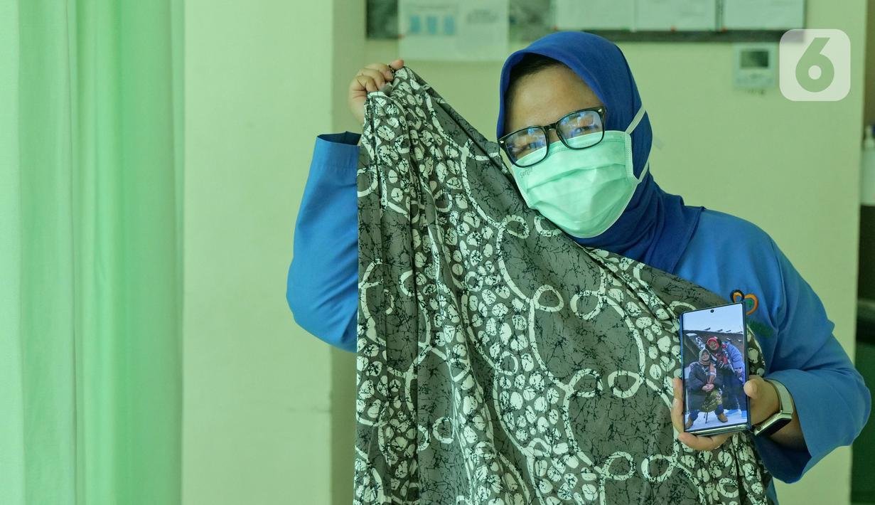 dr. Nurul Hidayah (34) menunjukkan foto ibunya saat di RSUD Pasar Minggu, Jakarta, Jumat (22/5/2020). Nurul Hodayah sudah 3 bulan tidak bertemu keluarga selama bertugas menjaga COVID -19 di RSUD Pasar Minggu. (Liputan6.com/Herman Zakharia)
