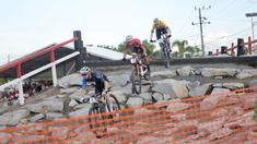 dari kiri, Pembalap Estonia, Kirill Tarassov, pembalap Singapura, Riyadh Hakim dan pembalap Ceko, Simon Nemec, beraksi di UCI MTB Eliminator World Cup 2024 yang digelar di Sirkuit SG 1973, Palangka Raya, Minggu (19/5/2024). (Bola.com/Ade Yusuf Satria)