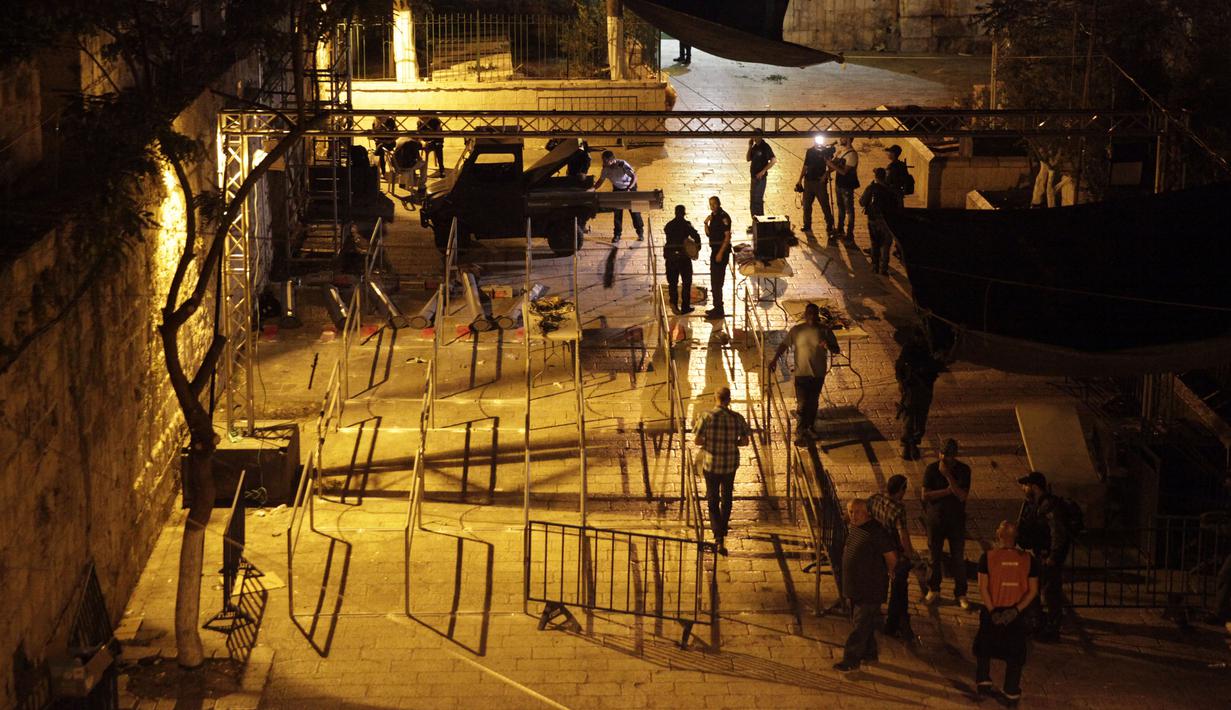 Aparat keamanan Israel membongkar detektor logam di depan pintu masuk kompleks Masjid Al Aqsa di Kota Tua Yerusalem, Selasa (25/7) dini hari. Hal itu dilakukan, setelah PM Israel Benyamin Netanyahu mengambil voting kabinet. (AP Photo/Mahmoud Illean)