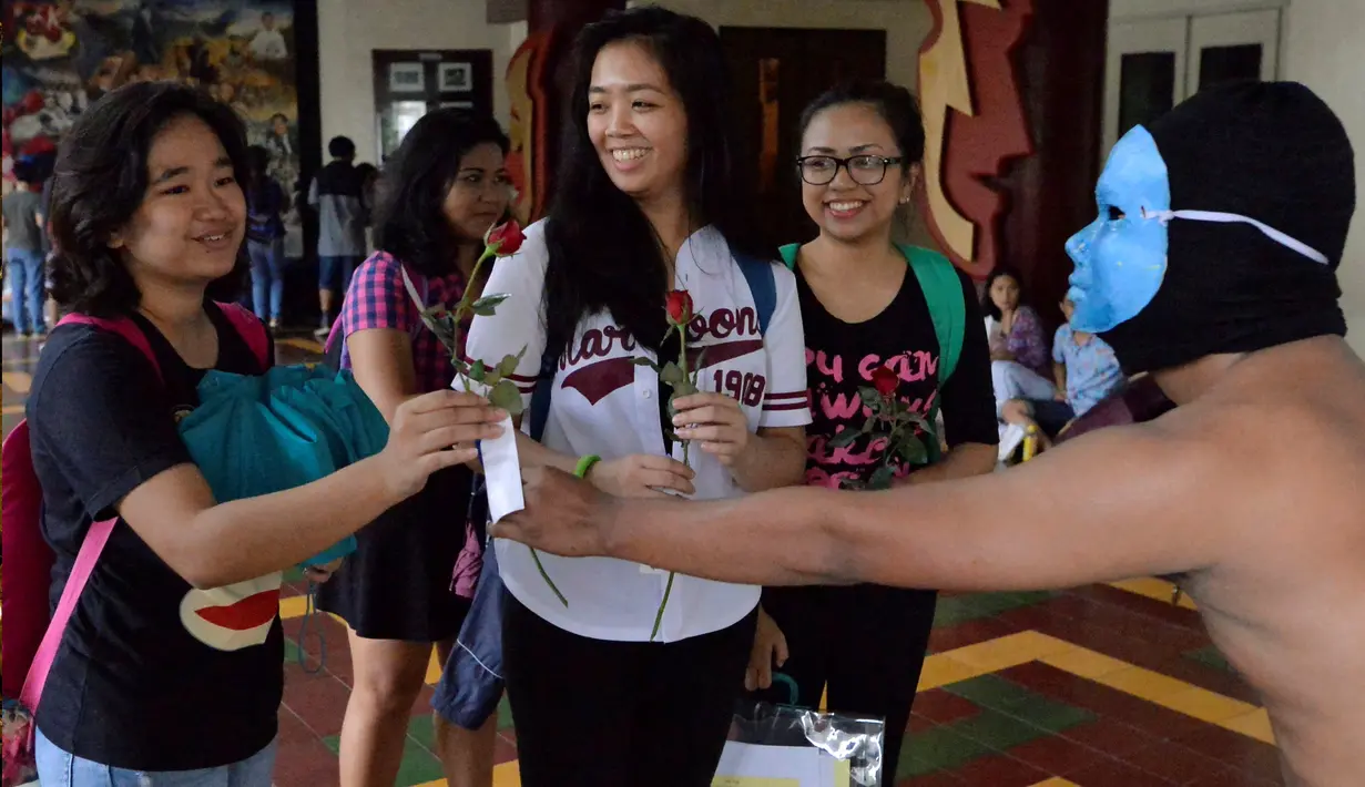Anggota Persaudaraan Alpha Phi Omega (APO) memberikan bunga kepada mahasiswi di Universitas Filipina (UP), Manila, Jumat (25/11). Demonstran memprotes pemakaman Ferdinand Marcos di Libingan ng mga Bayani (Taman Makam Pahlawan). (REUTERS / Ezra Acayan)