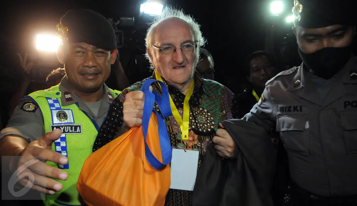 Rohaniawan pendamping narapidana Romo Carolus dikawal petugas saat menyeberang ke Pulau Nusa Kambangan, Cilacap, Jateng, (28/7). Rohaniawan dipanggil masuk ke Pulau Nusa Kambangan, jelang pelaksanaan eksekusi mati tahap III. (Liputan6.com/Helmi Afandi)