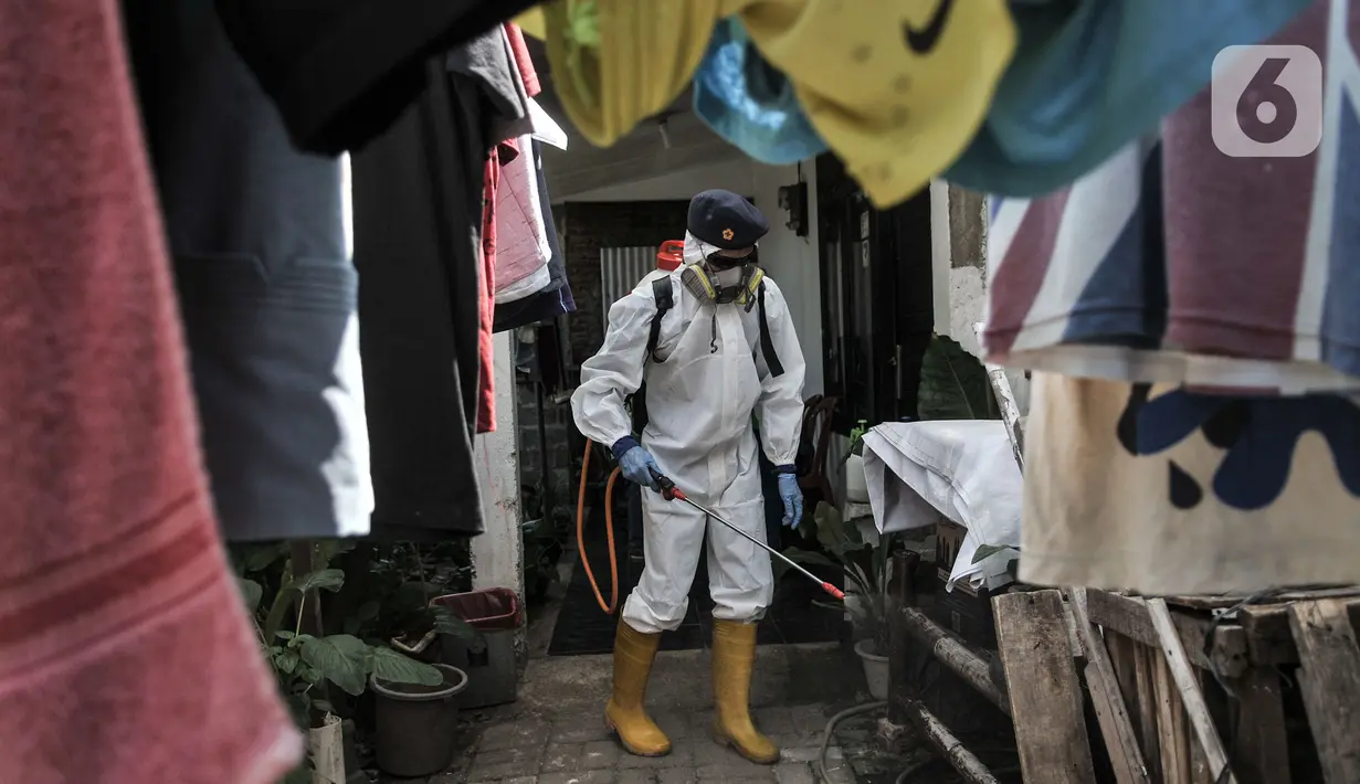 Petugas Palang Merah Indonesia (PMI) Jakarta Timur berpakaian APD menyemprotkan disinfektan di permukiman Kampung Tengah, Kramat Jati, Minggu (23/8/2020). Penyemprotan sebagai langkah sterilisasi permukiman setelah warga di Kampung Tengah dilaporkan terpapar Covid-19. (Liputan6.com/Iqbal Nugroho)