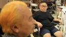 Le Phuc Hai, 66 tahun (kiri) dan To Gia Huy , 9 tahun, setelah rambut mereka dipangkas dengan gaya pemimpin Korea Utara Kim Jong-un dan Presiden Amerika Serikat, Donald Trump di sebuah salon di Hanoi, Vietnam, 19 Februari 2019. (AP/Hau Dinh)